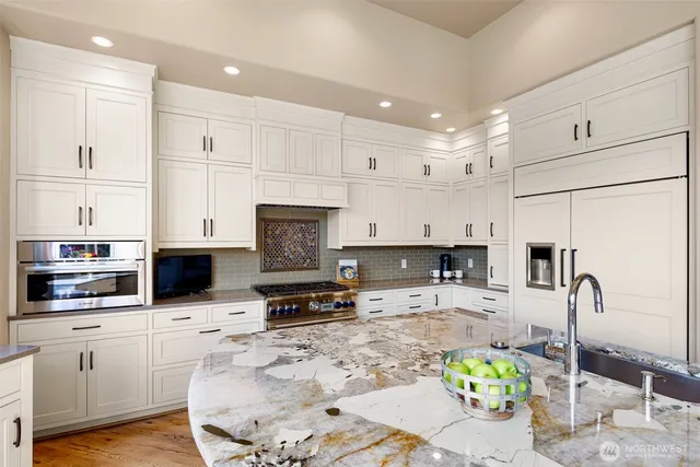 a kitchen with stainless steel appliances granite countertop a sink a stove top oven a counter space and cabinets