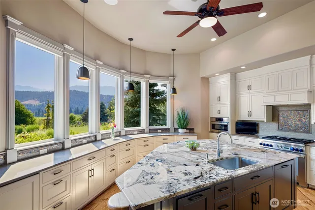 a kitchen with granite countertop a sink a counter top space appliances and cabinets