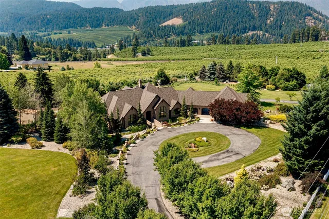 an aerial view of a house with a garden and lake view