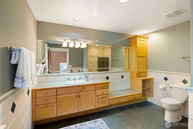 a spacious bathroom with a granite countertop sink and a mirror