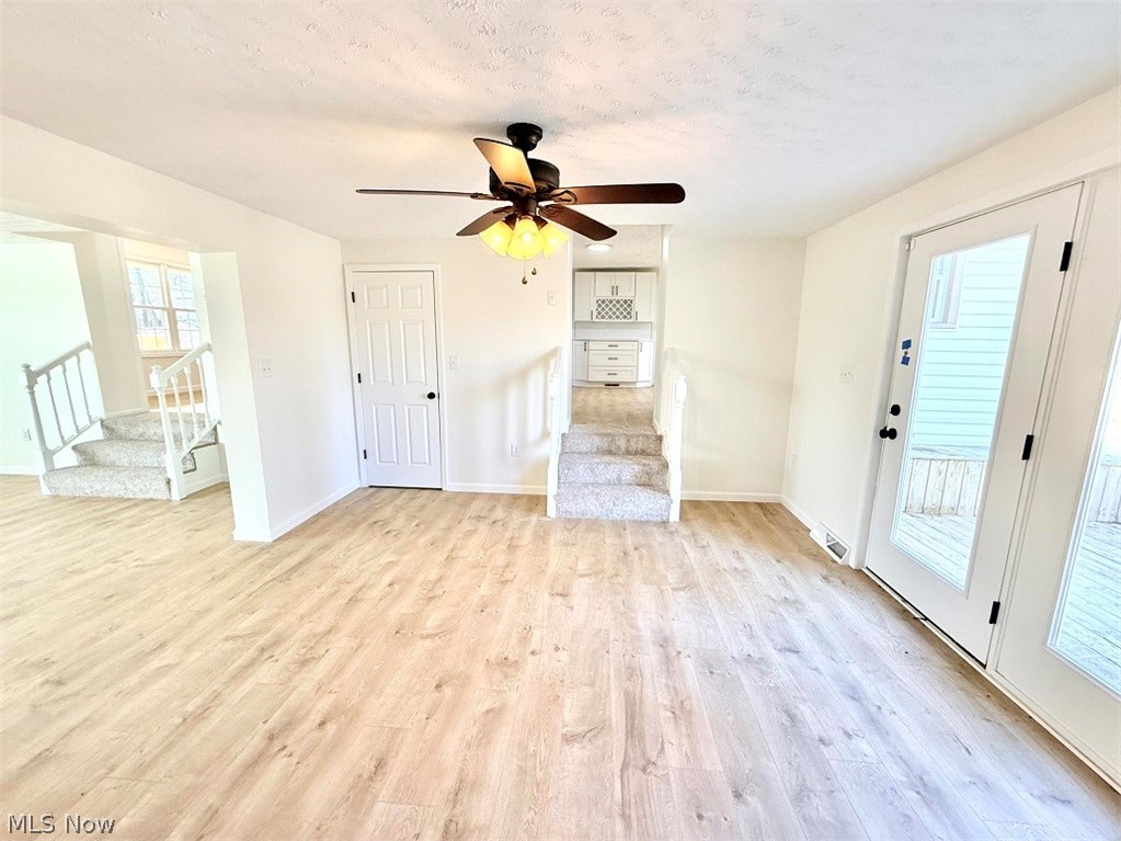 144 Aberdeen Road Steubenville, OH 43953 - Photo 8 of 34 Unfurnished living room featuring a ceiling fan, light wood-type flooring, and a textured ceiling