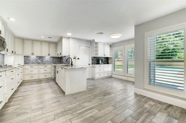 a kitchen with granite countertop white cabinets and stainless steel appliances