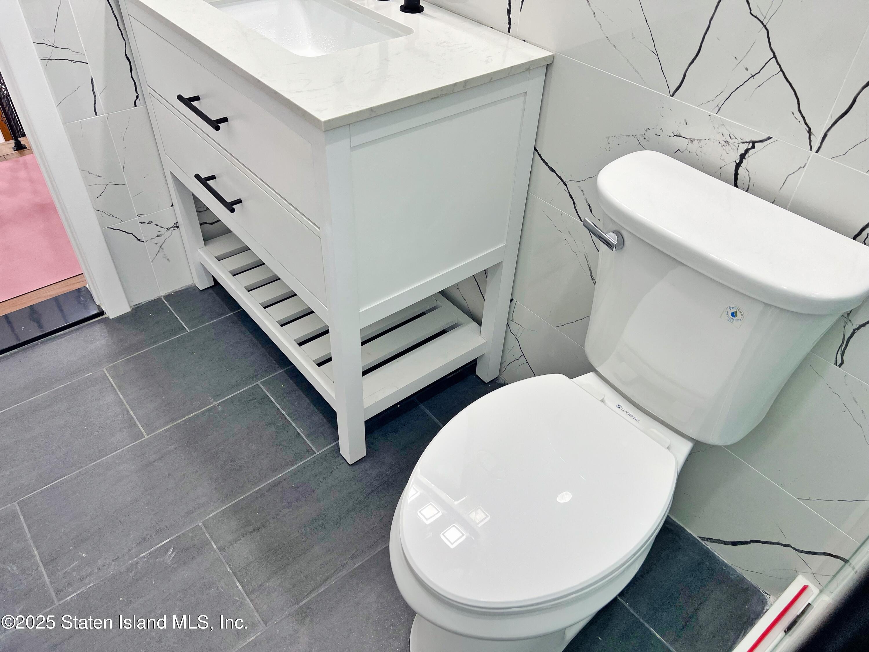 32 Remsen Street Staten Island, NY 10304 - Photo 14 of 41 a bathroom with a toilet a sink and mirror