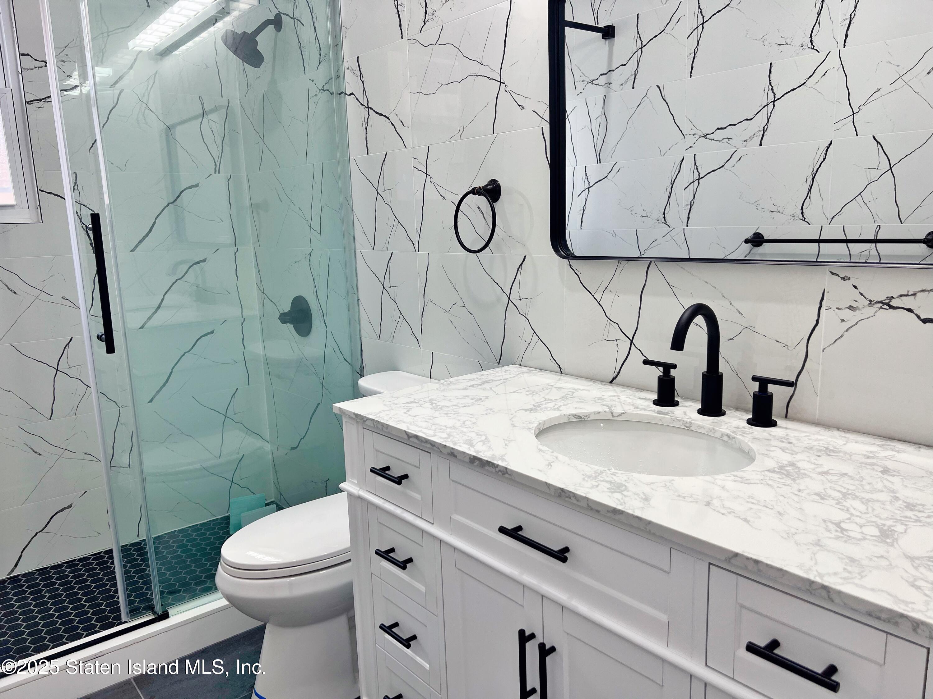 32 Remsen Street Staten Island, NY 10304 - Photo 19 of 41 a bathroom with a granite countertop sink mirror vanity and toilet