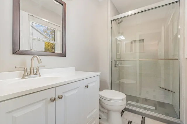 a bathroom with a sink a toilet and shower