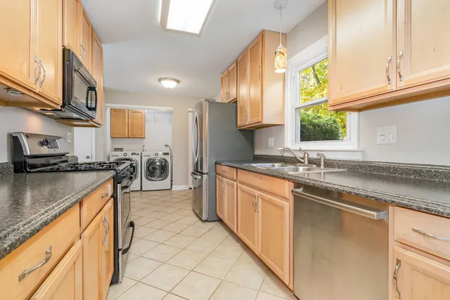 a kitchen with stainless steel appliances granite countertop a sink and a stove