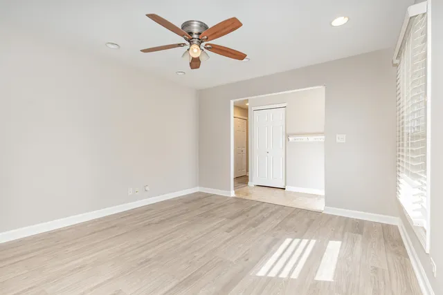 an empty room with wooden floor and windows
