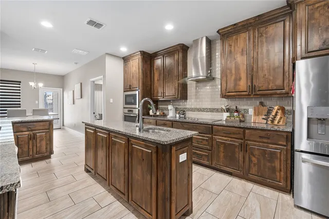 a kitchen with stainless steel appliances granite countertop a sink stove and refrigerator