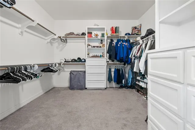 a view of walk in closet with clothes and shoes