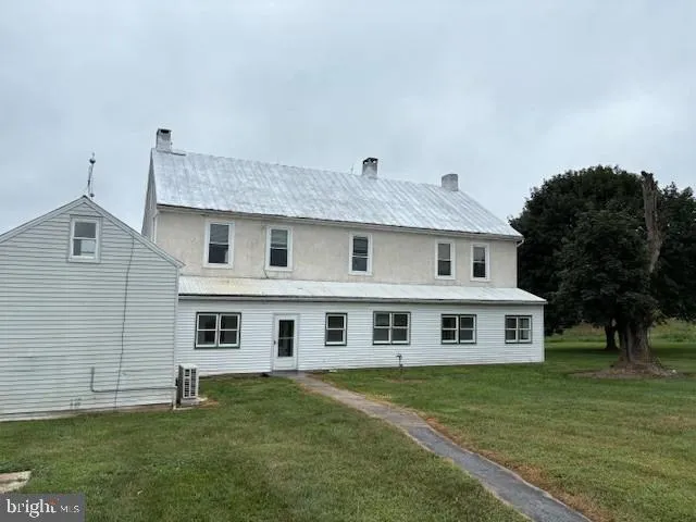 a big house with huge green field in front of it