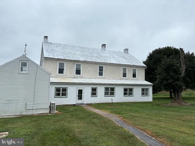a big house with huge green field in front of it
