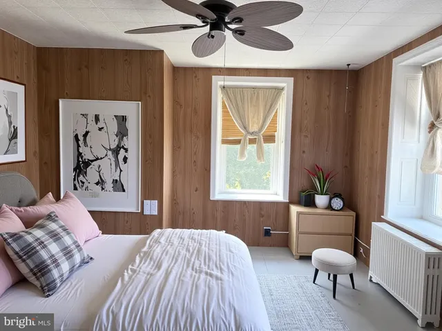 a bedroom with a bed and a large window