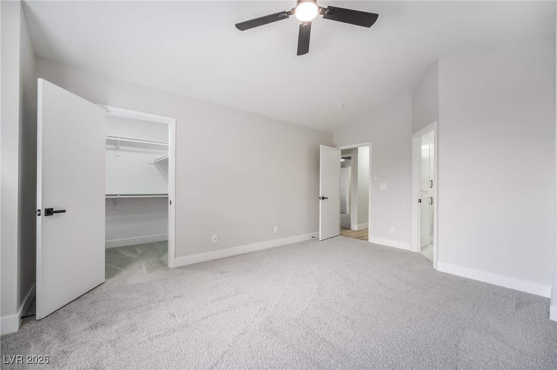 2850 Nikki Place Henderson, NV 89074 - Photo 18 of 64 Unfurnished bedroom with a spacious closet, light colored carpet, vaulted ceiling, and ceiling fan