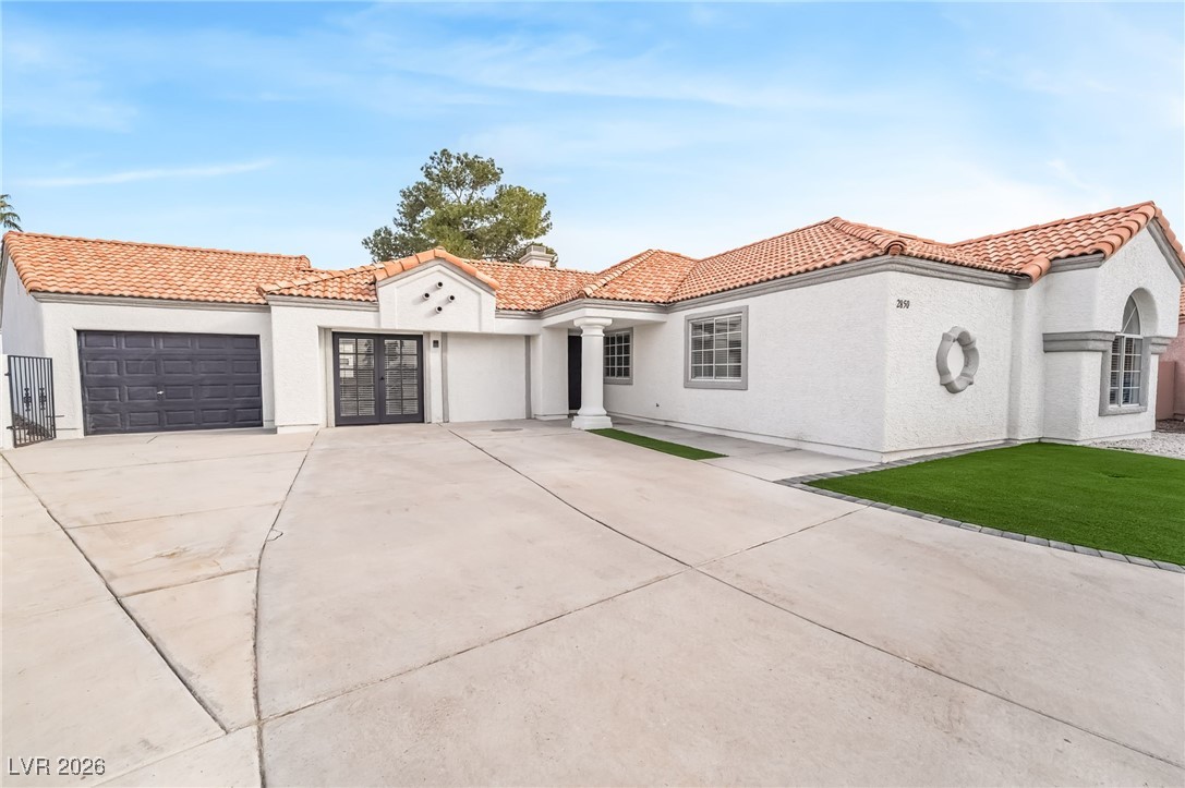2850 Nikki Place Henderson, NV 89074 - Photo 5 of 64 Mediterranean / spanish-style house with concrete driveway, an attached garage, stucco siding, and a tiled roof