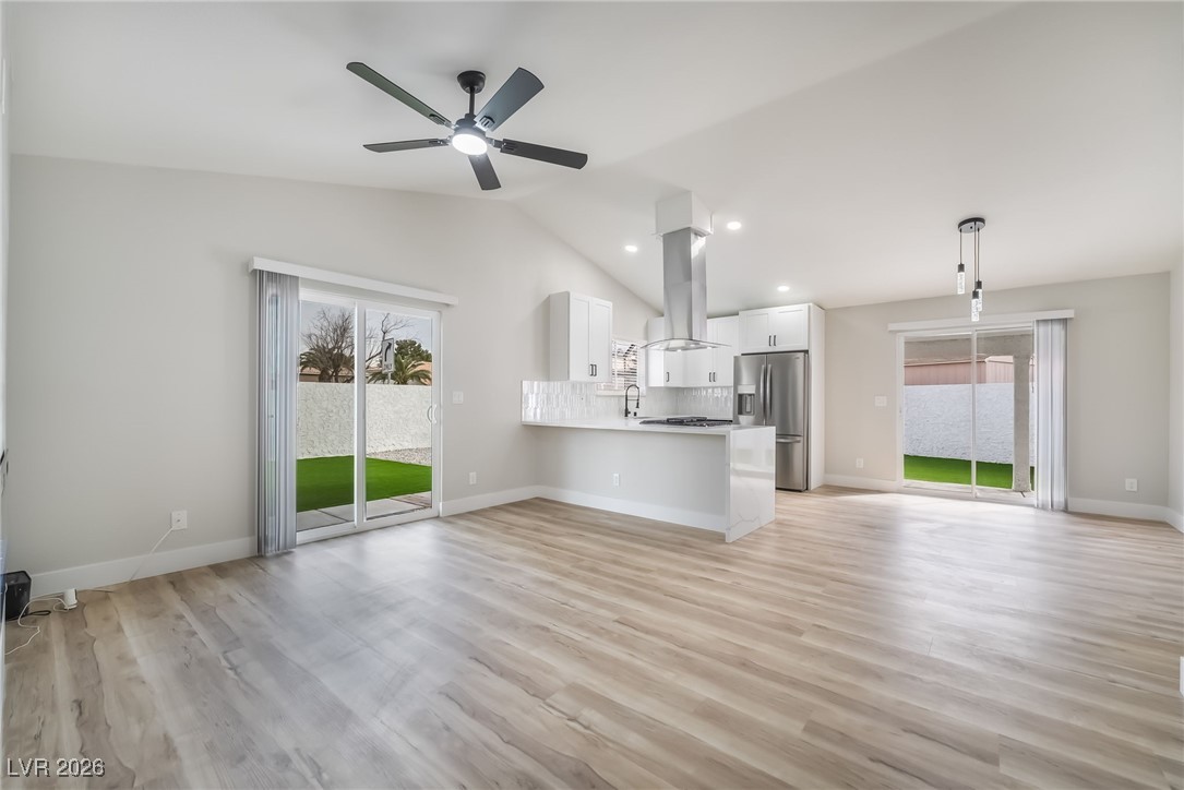 2850 Nikki Place Henderson, NV 89074 - Photo 6 of 64 Unfurnished living room featuring vaulted ceiling, a ceiling fan, recessed lighting, and light wood finished floors