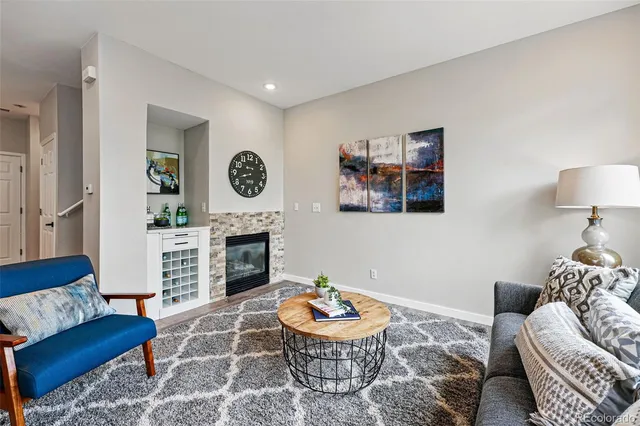 a living room with furniture a fireplace and a large mirror