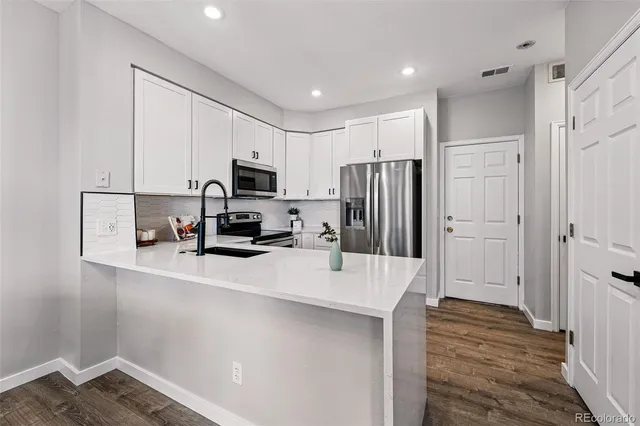 a kitchen with kitchen island a refrigerator sink and cabinets