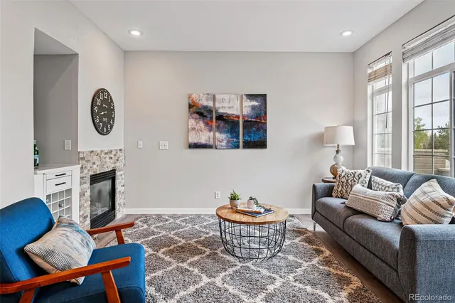 a living room with furniture a fireplace and a large window