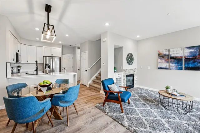 a living room with furniture kitchen view and a chandelier