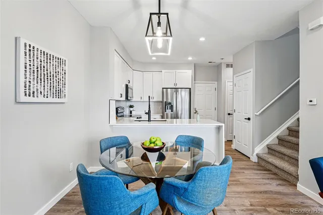 a view of a dining room with furniture a chandelier and wooden floor