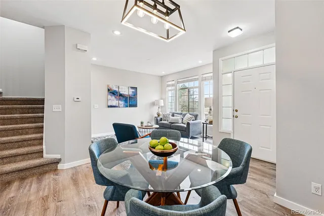 a view of a dining room with furniture a rug and wooden floor