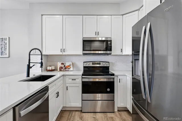 a kitchen with refrigerator a microwave a sink and cabinets