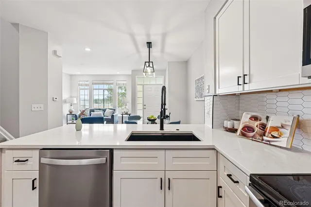 a kitchen with white cabinets and window