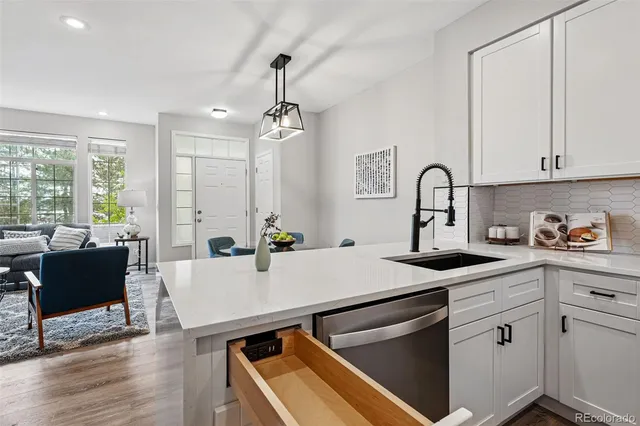 a kitchen with a sink appliances and wooden floor