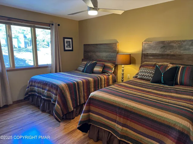 a bedroom with two beds and a large window