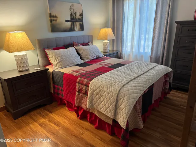 a bedroom with a bed and wooden floor