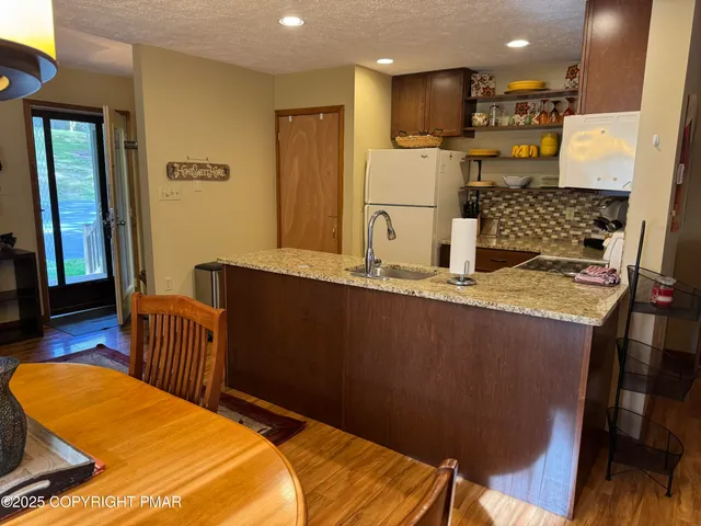 a kitchen with stainless steel appliances granite countertop a sink refrigerator and cabinets