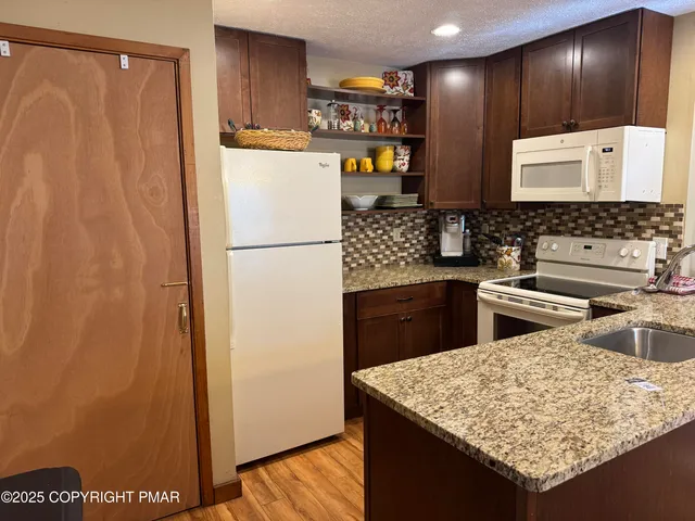 a kitchen with stainless steel appliances granite countertop a refrigerator and a stove