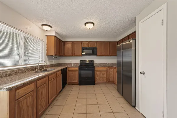 a kitchen with a sink a refrigerator and cabinets