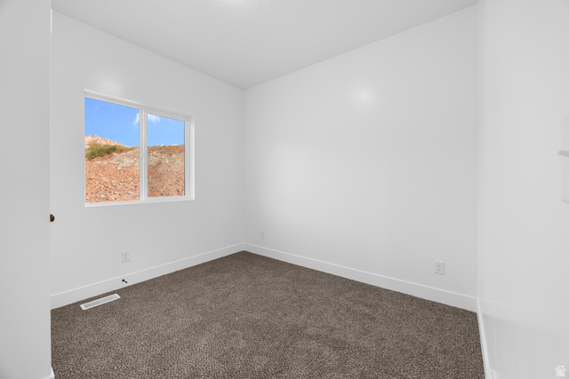 1563 South Deerbrook Road, Unit 267CHM Santaquin, UT 84655 - Photo 12 of 13 White-painted interior room featuring a large window, neutral-toned carpet flooring, white baseboards, and a visible electrical outlet