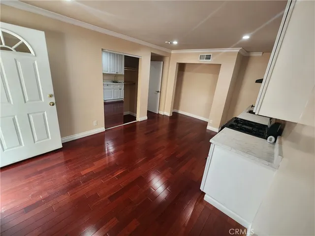 a view of empty room with wooden floor