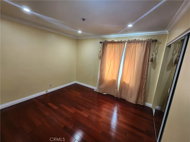 an empty room with wooden floor and a window