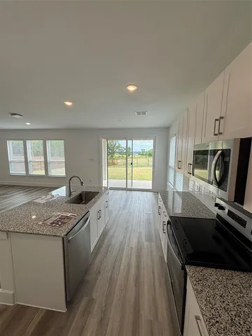 a kitchen with granite countertop stainless steel appliances a stove sink and microwave