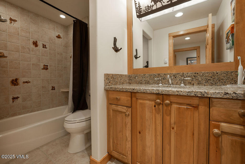 4454 Bellyache Ridge Road Wolcott, CO 81655 - Photo 20 of 48 a bathroom with a granite countertop sink a toilet a mirror and bathtub