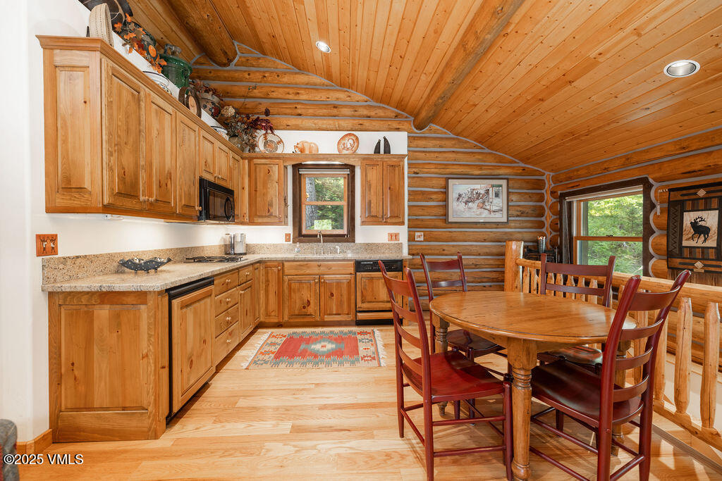 4454 Bellyache Ridge Road Wolcott, CO 81655 - Photo 23 of 48 a kitchen with stainless steel appliances granite countertop a stove top oven a sink a dining table and chairs with wooden floor
