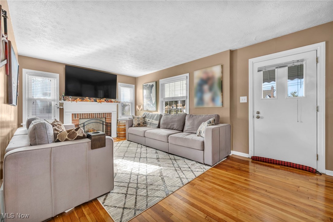 1645 Lander Road Cleveland, OH 44124 - Photo 14 of 38 Living room with a fireplace, light hardwood / wood-style floors, and a textured ceiling