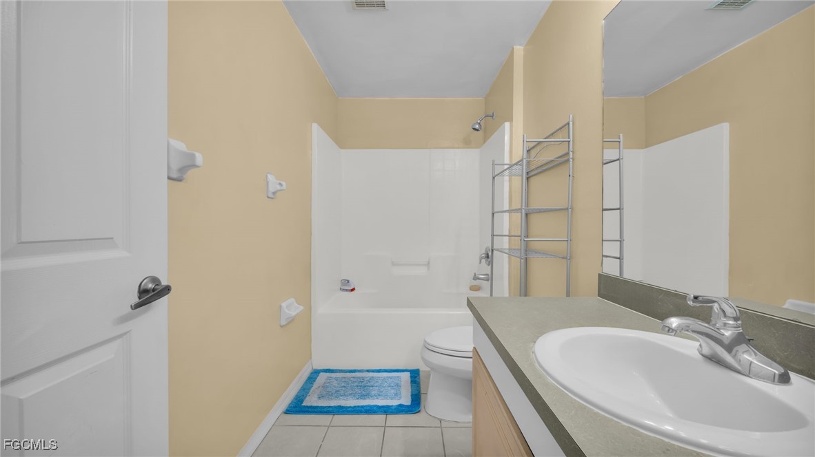 4551 22nd Street Southwest Lehigh Acres, FL 33973 - Photo 19 of 26 a bathroom with a granite countertop sink a toilet and shower