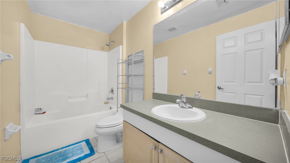 4551 22nd Street Southwest Lehigh Acres, FL 33973 - Photo 20 of 26 a bathroom with a granite countertop sink toilet and shower