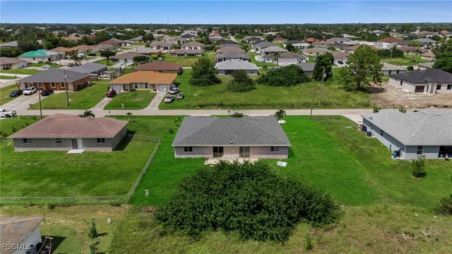an aerial view of a house with garden space and mountain view in back