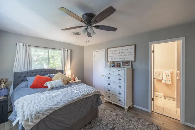 a bedroom with a bed and a flat tv screen on dresser