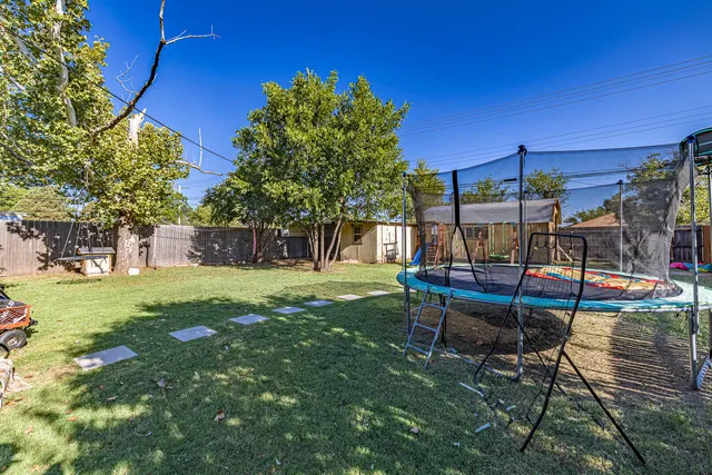 a swimming pool with yard in front of it