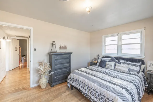 a bedroom with a bed and wooden floor