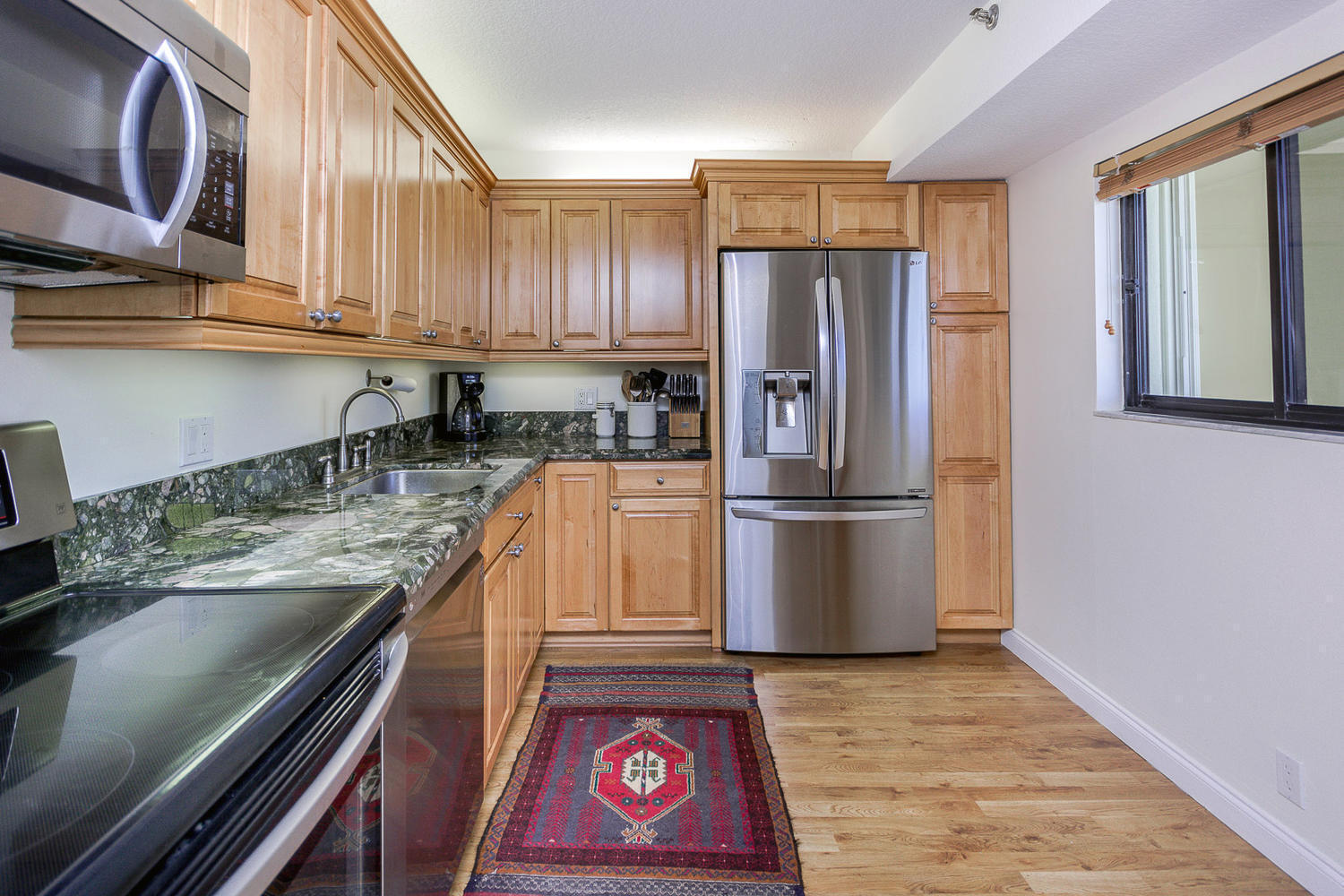 400 Ocean Trail Way, Unit 904 Jupiter, FL 33477 - Photo 11 of 31 a kitchen with stainless steel appliances granite countertop a refrigerator a stove a sink and dishwasher
