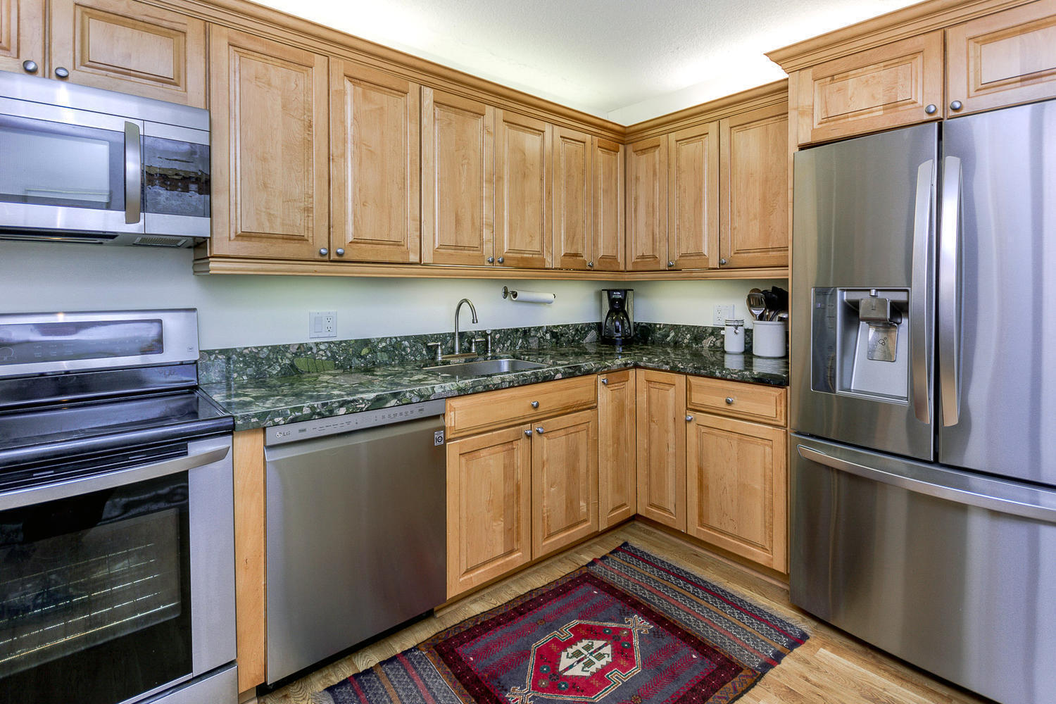 400 Ocean Trail Way, Unit 904 Jupiter, FL 33477 - Photo 12 of 31 a kitchen with granite countertop a refrigerator stove and cabinets