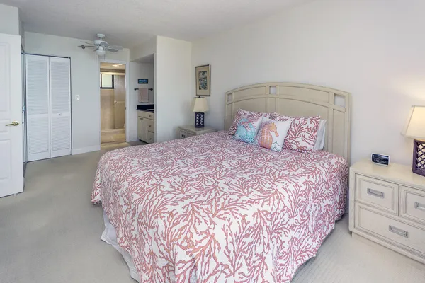 a bedroom with a large bed and wooden floor