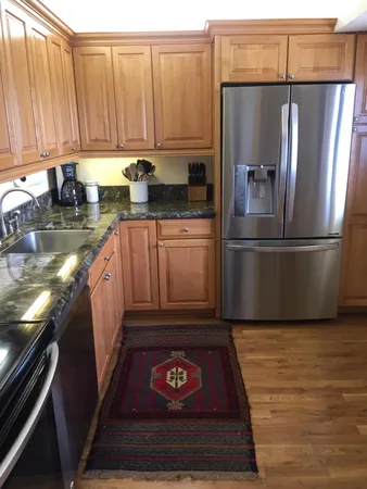 a kitchen with stainless steel appliances granite countertop a refrigerator stove and sink